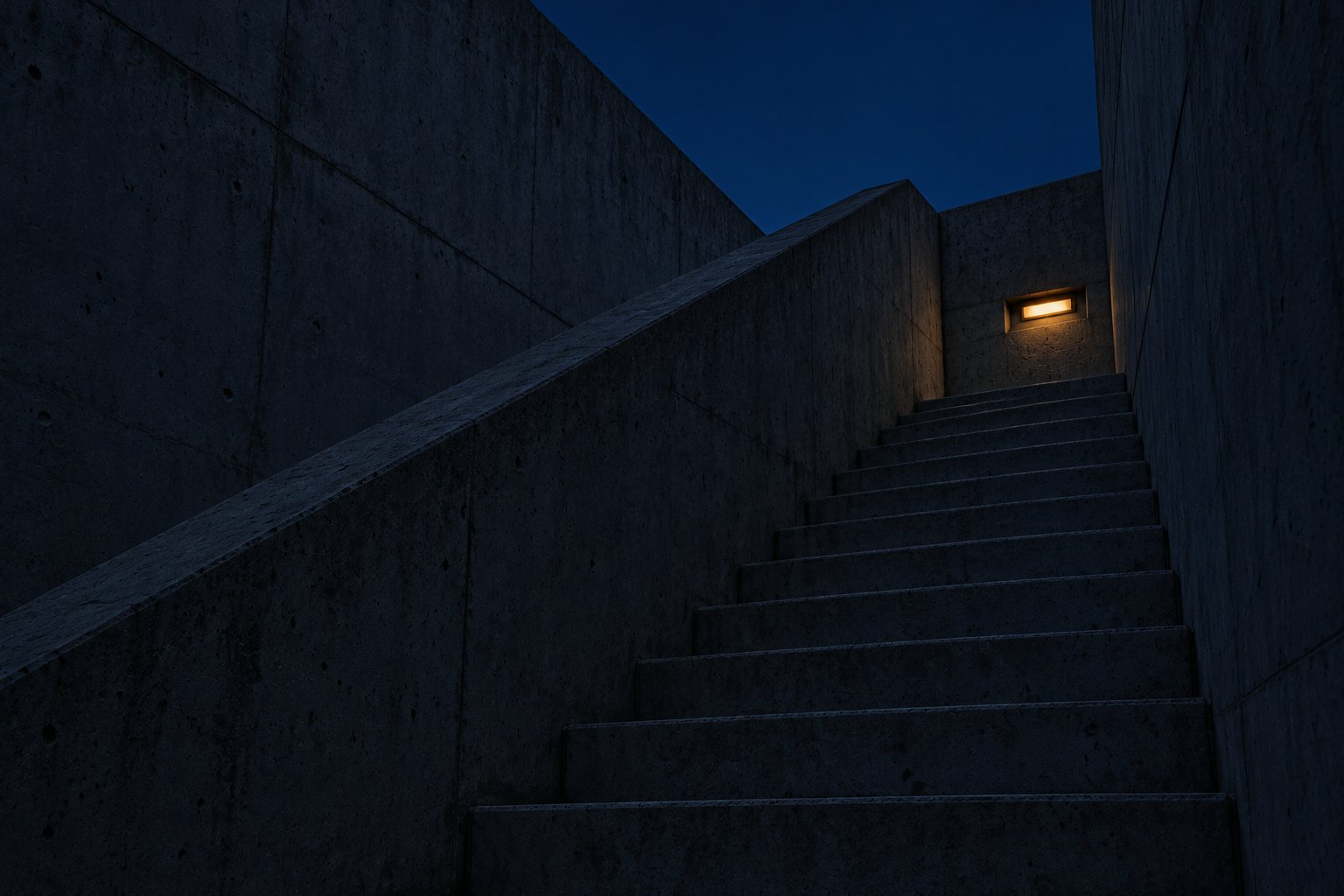 A concrete staircase at dusk rising towards one warm light